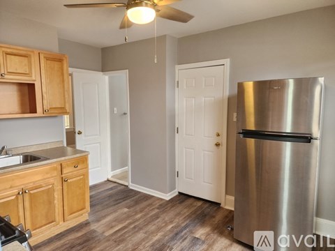 A kitchen with wooden cabinets and a stainless steel refrigerator.