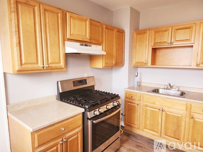 A kitchen with wooden cabinets and a black stove top oven.