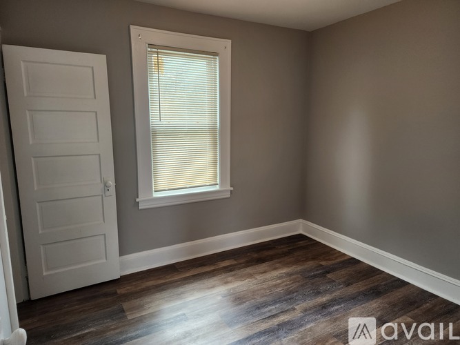 A room with a white door and a window with blinds.