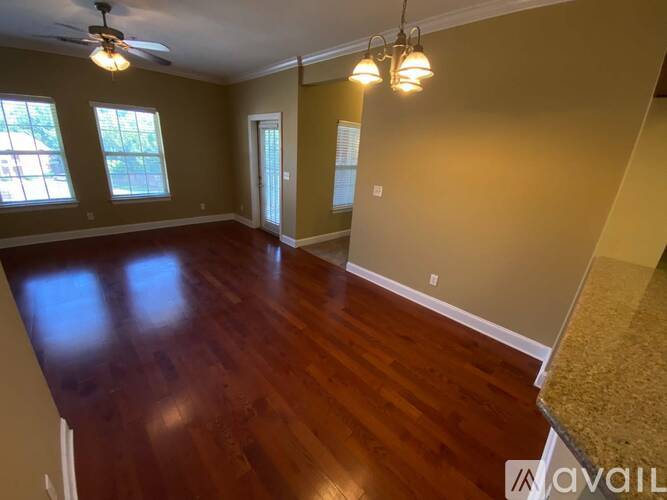 A room with wood flooring and a ceiling fan.