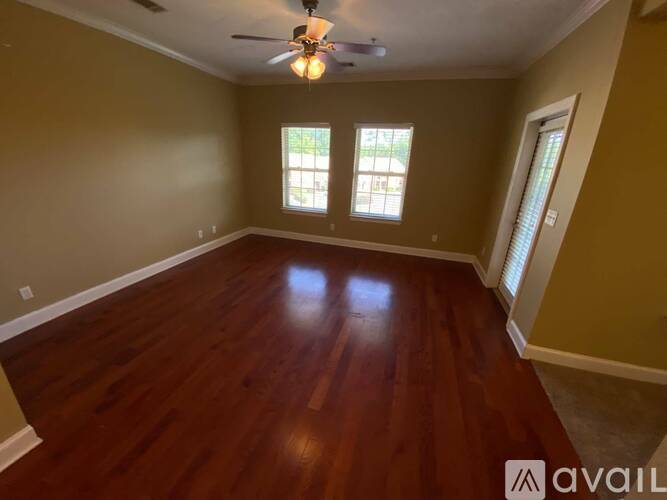 A room with wooden floors and a ceiling fan.