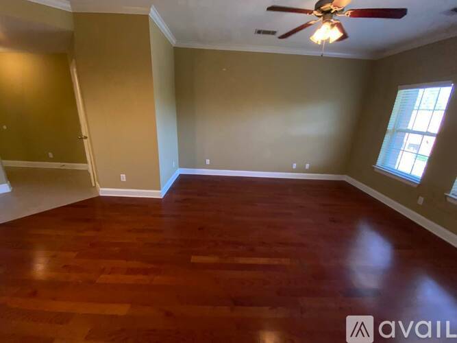 A room with wooden flooring and a ceiling fan.