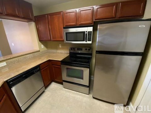 A kitchen with brown cabinets and stainless steel appliances.