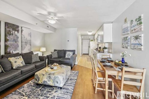 A living room with a grey couch and a coffee table with a floral pattern.