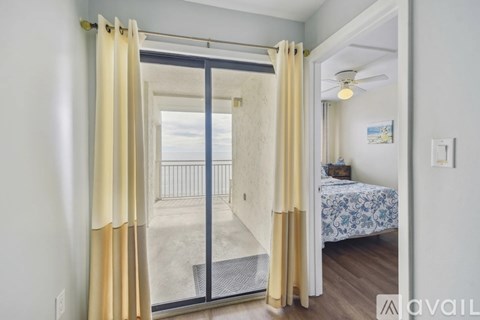 A bedroom with a bed and a sliding glass door leading to a balcony.