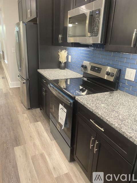 A kitchen with black cabinets and a granite countertop.