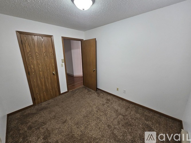 A room with two doors and carpeted floor.