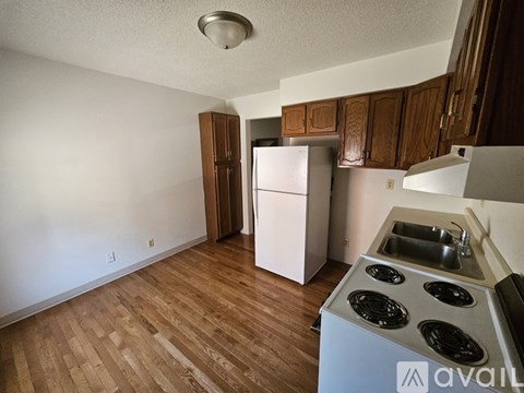 A kitchen with a stove top oven and a refrigerator.