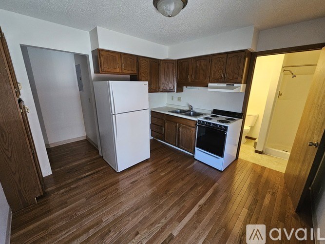 A kitchen with wooden floors and white appliances.