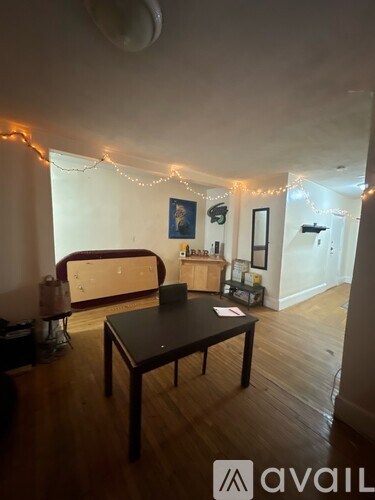 A living room with a couch, coffee table, and Christmas lights.