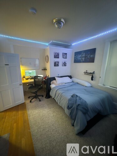 A bedroom with a bed, desk, and chair.