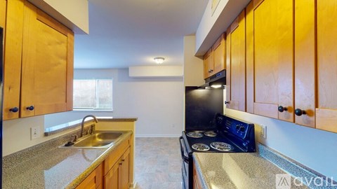 A kitchen with wooden cabinets and a black stove top oven.