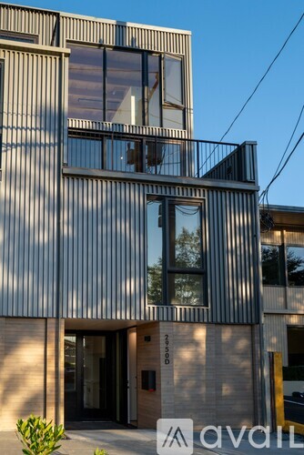 A modern building with a corrugated metal facade and large windows.