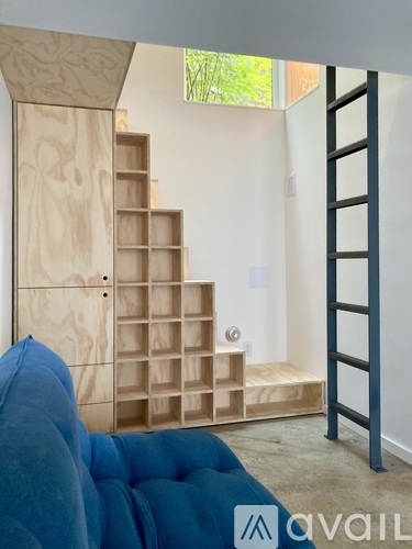 A blue sofa in front of a wooden staircase.