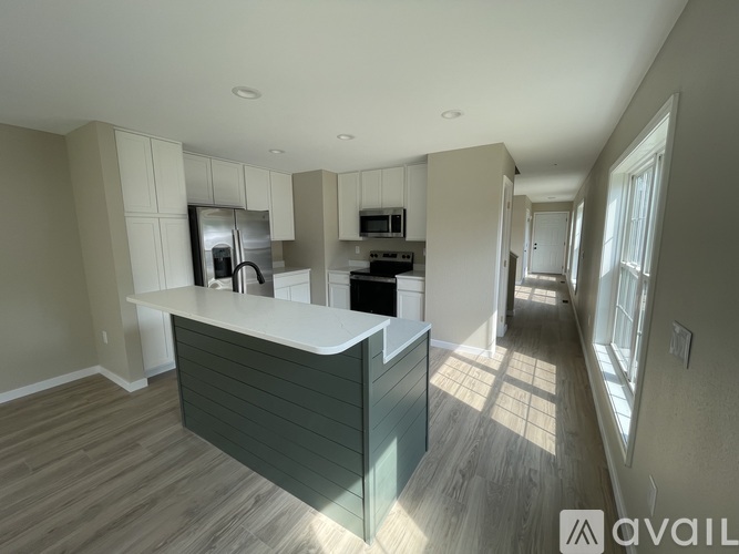 A spacious kitchen with a breakfast bar and wooden floors.