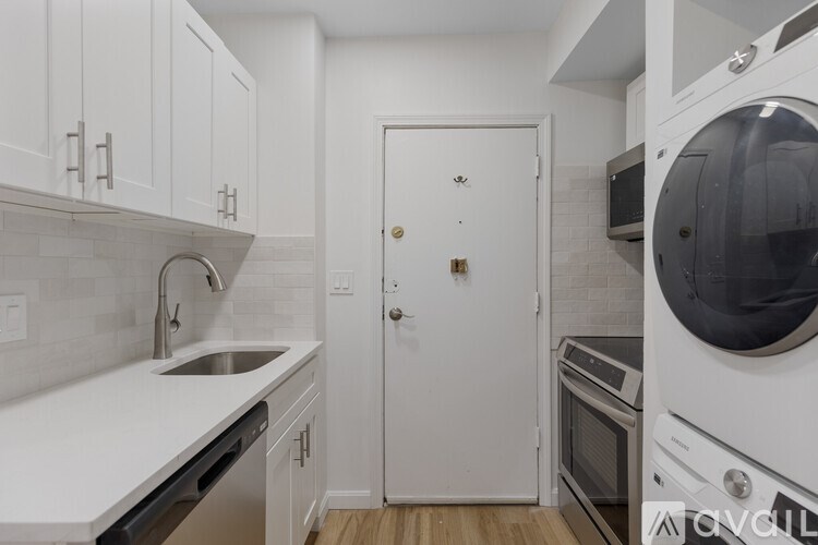 A white kitchen with a sink, dishwasher, and oven.
