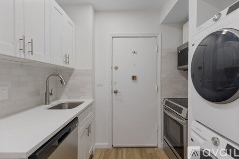 A white kitchen with a sink, dishwasher, and oven.