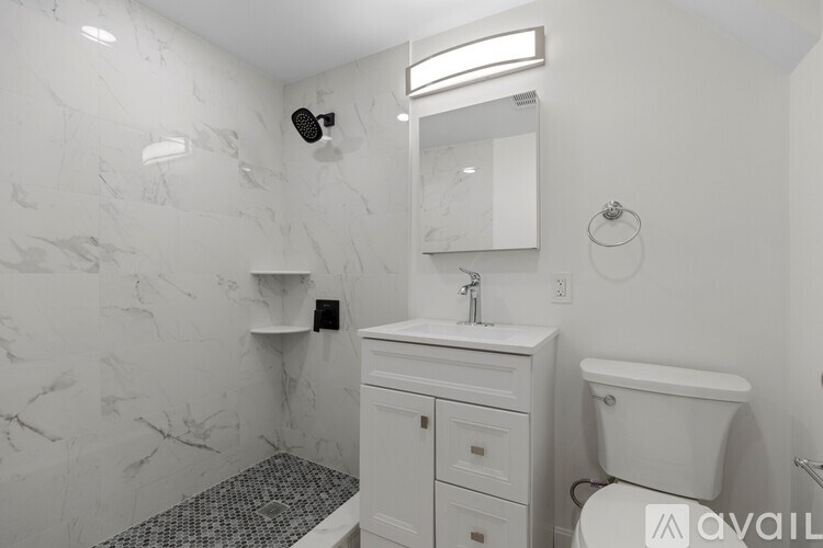 A bathroom with marble walls and a white toilet.
