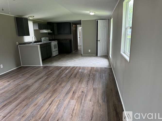 A kitchen with wood flooring and a white door.