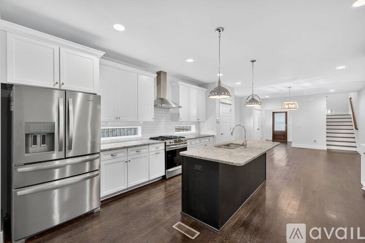A modern kitchen with stainless steel appliances and white cabinets.