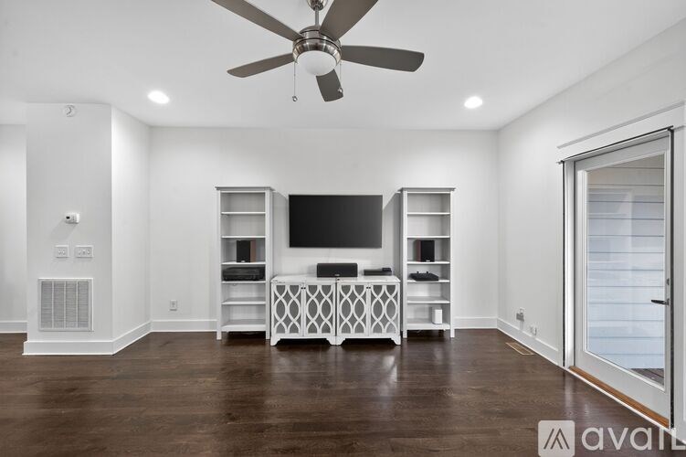 A spacious living room with a television and entertainment center.