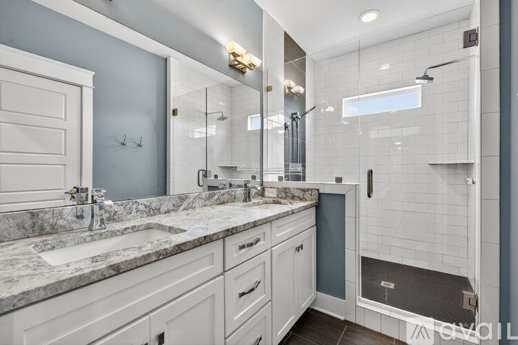 A bathroom with a marble countertop and a walk-in shower.