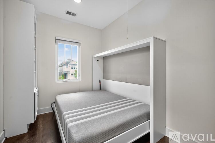 A bedroom with a bed, a window, and a door.