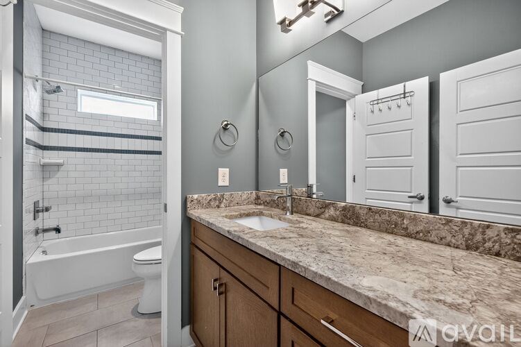 A bathroom with a marble countertop and a white bathtub.