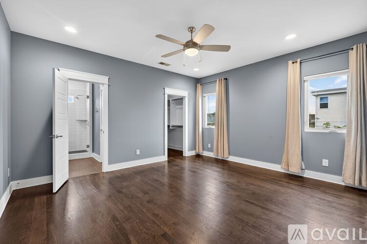 A spacious room with a ceiling fan and sliding glass doors.