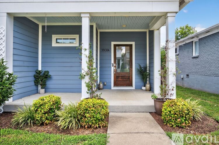 A blue house with a white porch and a brown door.