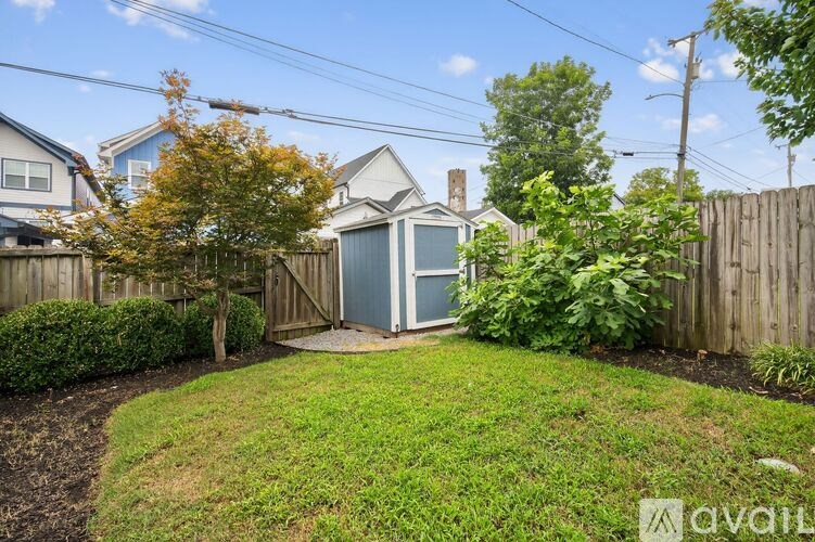 A backyard with a wooden fence and a small shed.
