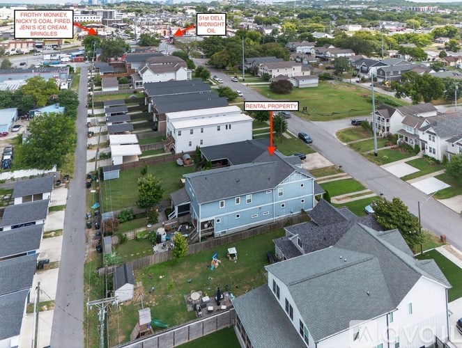 A bird's eye view of a residential area with a blue house in the foreground and a sign that reads "FROZEN MONKEY JIN'S CREAM BURGERS".