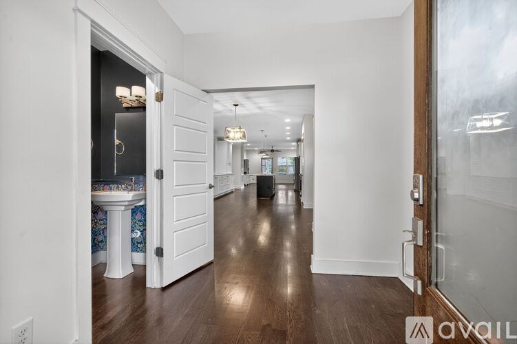 A hallway with a white door and a white table with a blue and white table cloth on it.