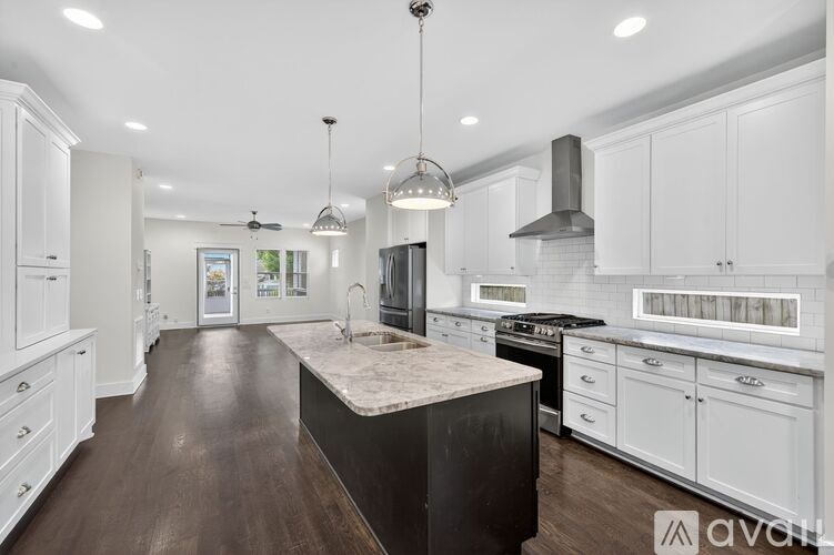 A modern kitchen with white cabinets and a central island.