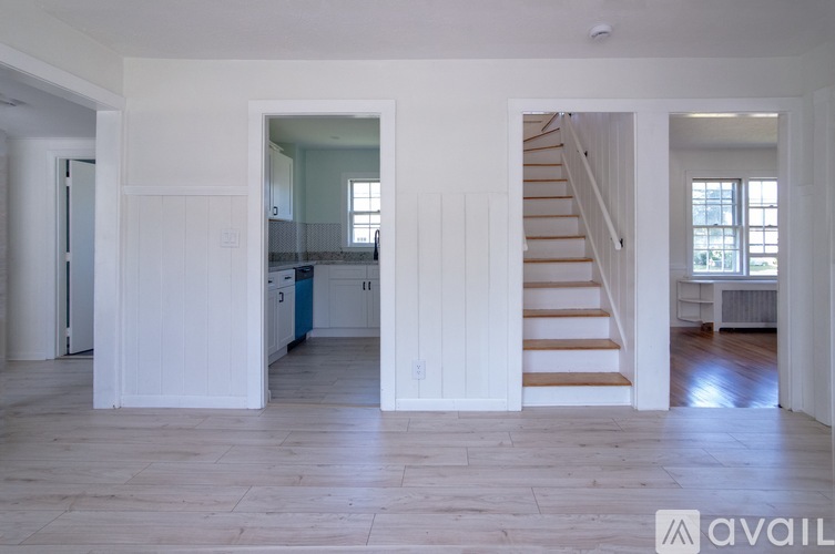 A spacious living area with a staircase leading to the upper floor.