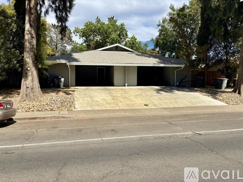 A house with a grey roof and a car parked in front.