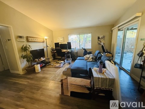 A living room with a couch, a coffee table, and a fireplace with a sign that says Nashville on the wall.