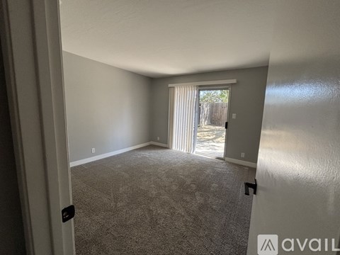 A backyard with a patio, chairs, and a tree.