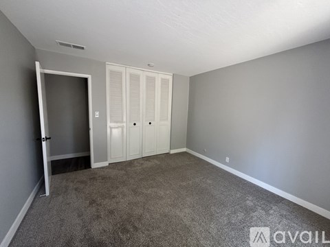 A backyard with a concrete patio and a tree.