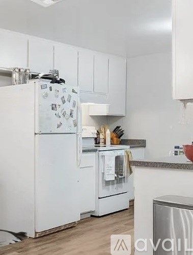 A white refrigerator with magnets on it is in a kitchen.
