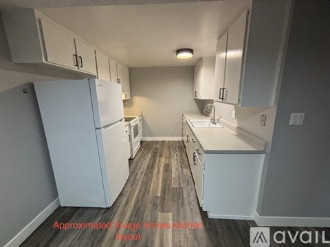 A small, modern kitchen with white appliances and cabinets.