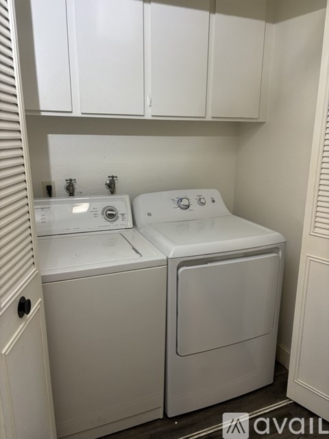 A kitchen with a white refrigerator and a black countertop.
