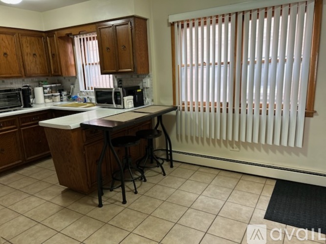 A kitchen with a white counter top and wooden cabinets.