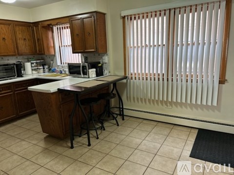 A kitchen with a white counter top and wooden cabinets.