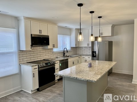 A kitchen with granite countertops and a black stove top oven.