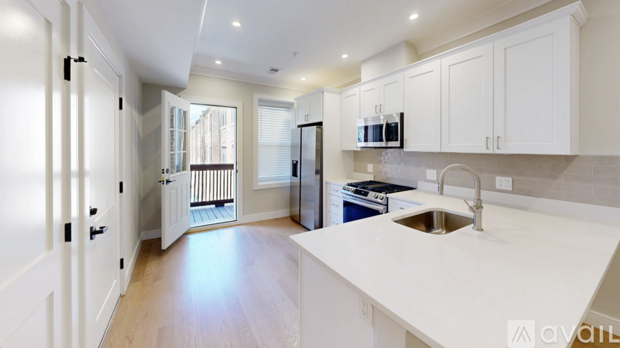 A kitchen with white cabinets and a white countertop.