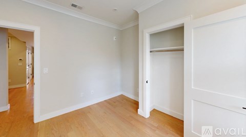 A room with a white wall and wooden floor.