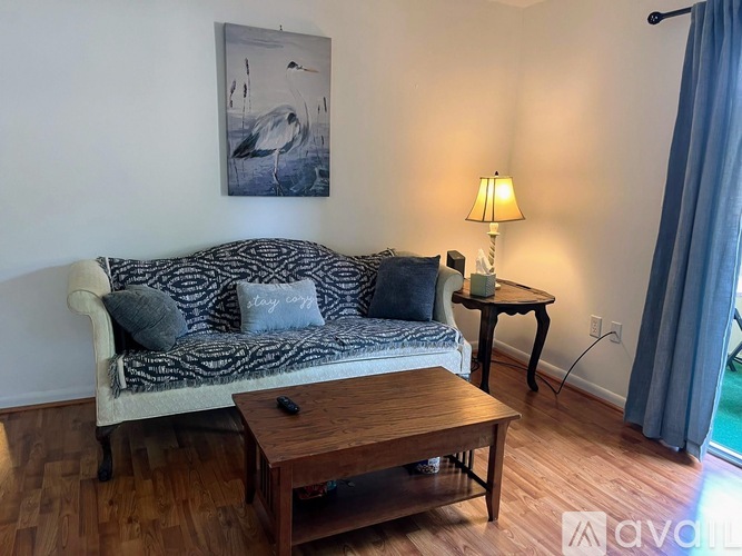 A living room with a couch, a table, and a painting on the wall.
