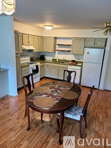A kitchen with a table and chairs in the middle.