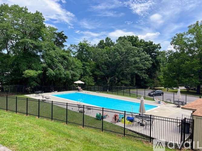 A black fence surrounds a blue swimming pool.